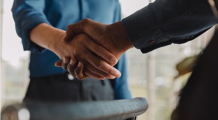 The beneficiary of a trust shakes hands with the trustee.