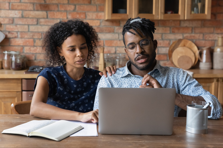 A couple holds a Zoom call with their financial advisor