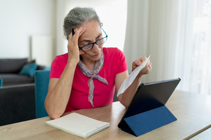An older woman studies her tax-advantaged accounts.