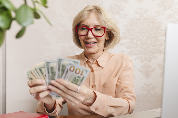 A senior woman counting her cash assets.