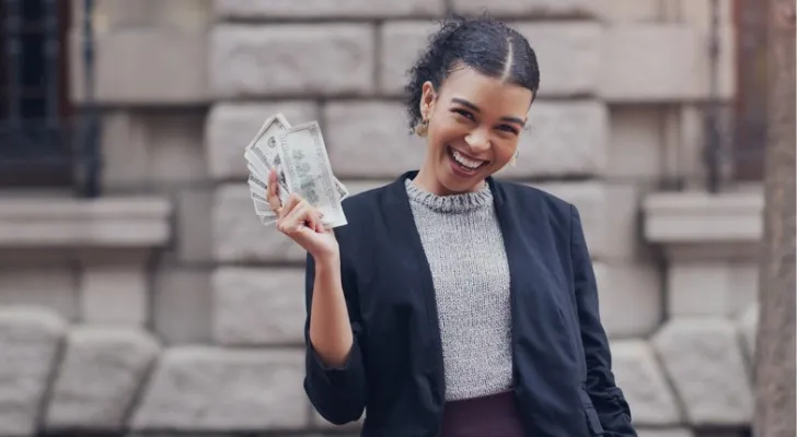 A woman holding a stack of cash.
