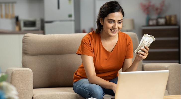 A woman excited to see that the minimum balance requirement for her online savings account is doable.