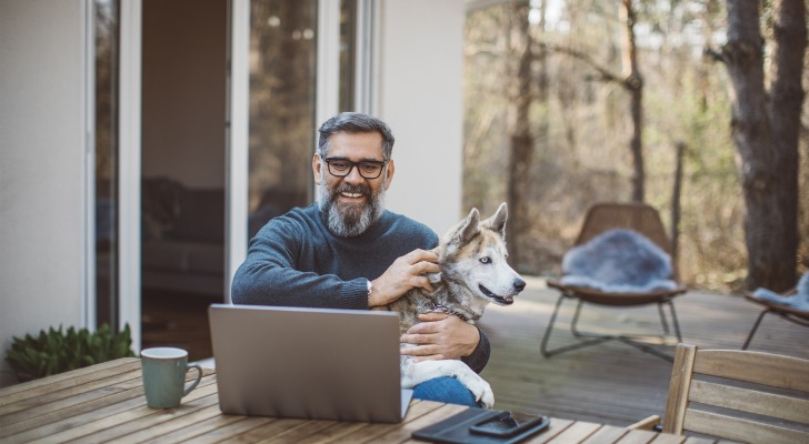 A man considers an indirect rollover while sitting on his deck with his dog.