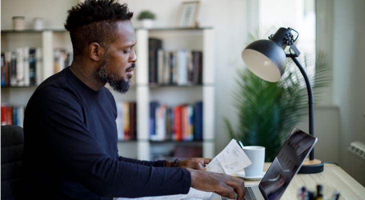A man adds up his income in preparation to file his taxes.