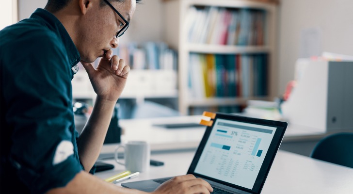 A man reviews his retirement savings on his laptop.