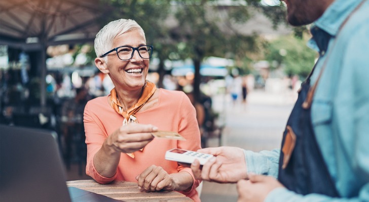 A woman makes a contactless payment using a credit card.