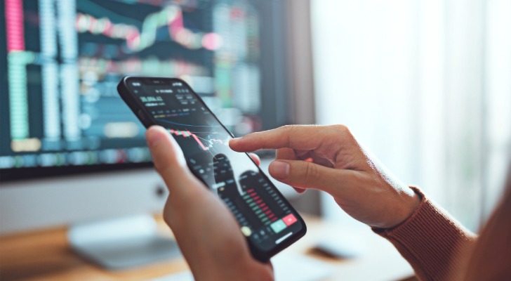 An investor monitors her portfolio on her phone.