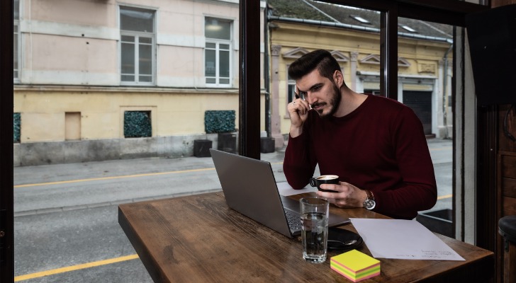 An expat working overseas from a coffee shop looking for a financial advisor.