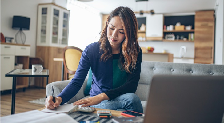 An investor takes notes as she compares mutual funds with a range of fees.