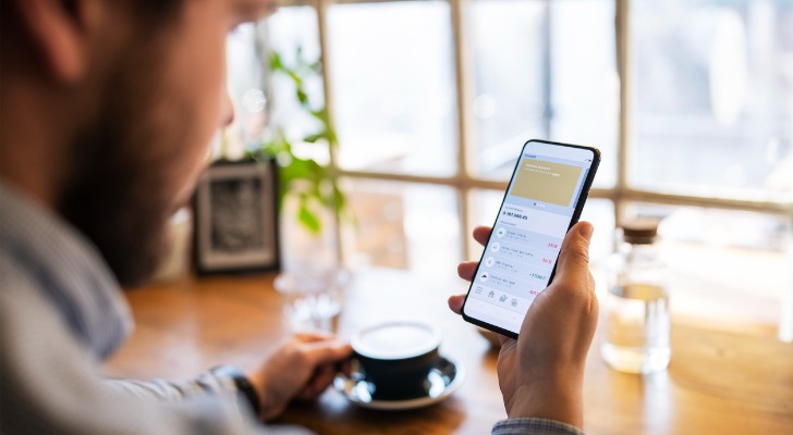 A man checks his investments portfolio, which is in the custody of a large brokerage firm.