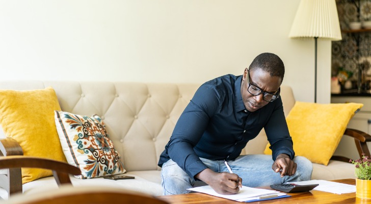 A man calculating the differences between ETFs, mutual funds and index funds.