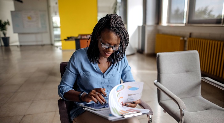 A woman calculating how much she will pay in penalties for cashing out her 401(k)