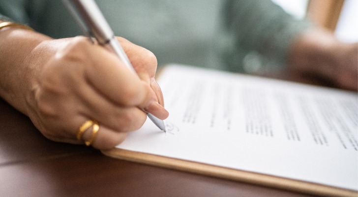 A woman signs paperwork creating a trust for her children.