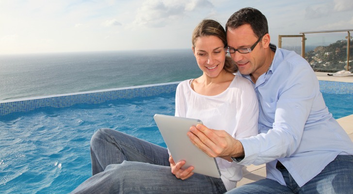 An ultra-high-net-worth couple reviews their tax plan on a table while sitting poolside.