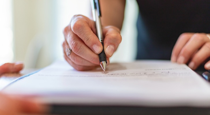 A woman signs a deed adding her new husband as a legal owner of her home.