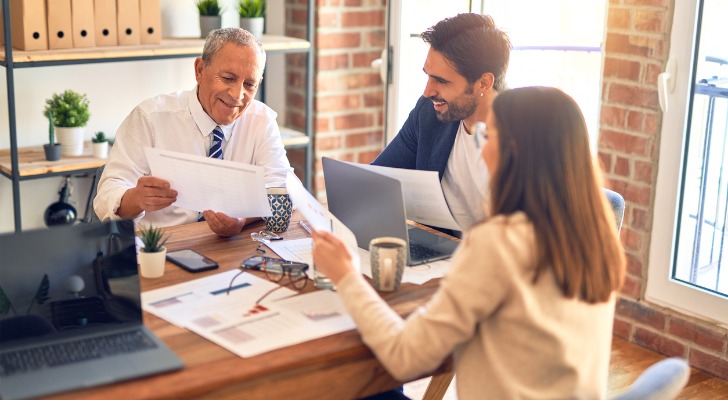 A senior man working with a financial advisor to review tax liabilities.