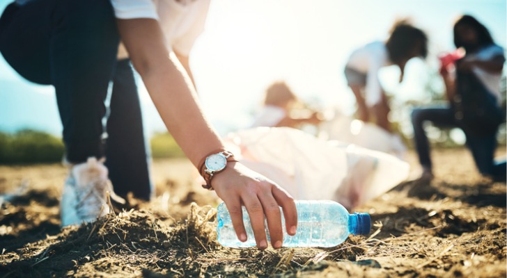 A woman picks up an empty plastic bottle as part of the work her family's private foundation does for the environment.
