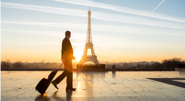 An American businessman based in Paris glances at the Eiffel Tower while on his way to work.