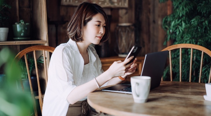 An investor looks over her retirement portfolio on her phone.