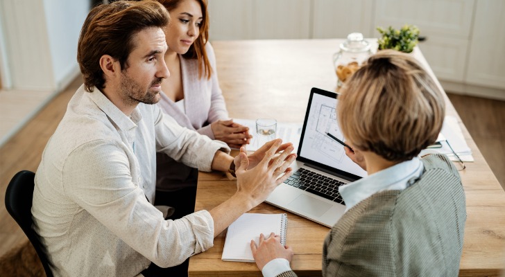 A couple being explained how an equity-indexed life insurance policy works by their financial advisor