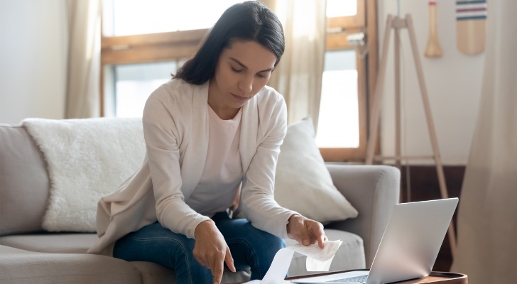 A woman examining receipts for passive and non-passive income.
