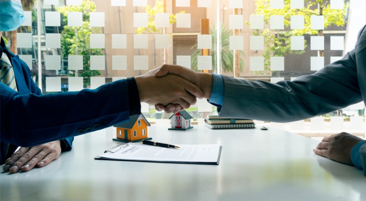 Two investors shake hands after agreeing to a real estate limited partnership (RELP)