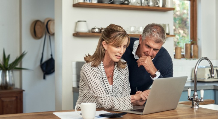 A couple looks over their retirement accounts while planning out when they can retire.