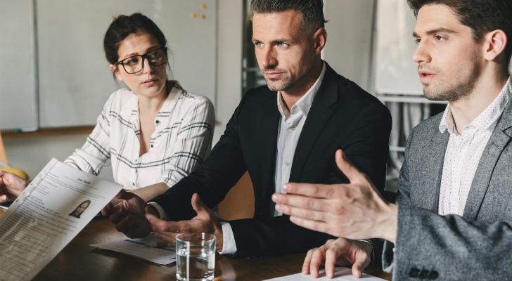 Financial advisors reviewing resumes for associate advisor candidates.