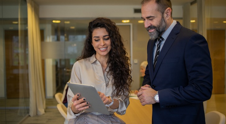 A financial advisor showing a client how their real estate investments are performing.