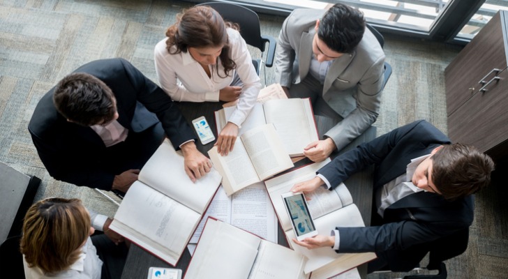 A group of financial advisors reviewing the sale of a book of business.