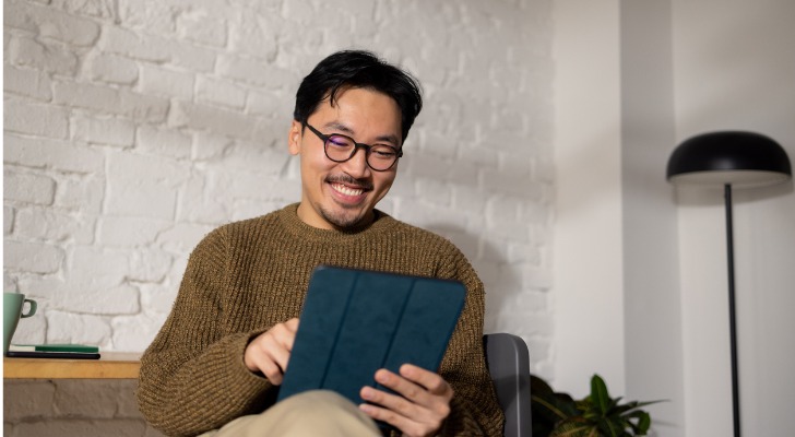 A man confidently reviews the terms of his loan, knowing that he has the requisite information about the terms and charges thanks to the Truth in Lending Act.