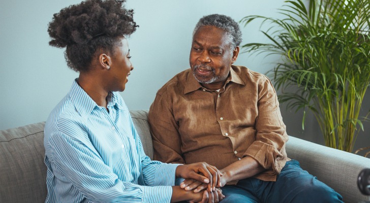 A woman sits with her father and discusses his estate plan.