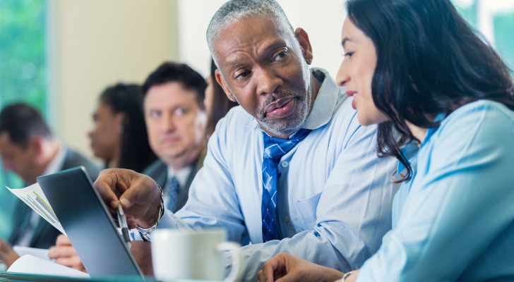 A financial advisor explaining the differences between a living trust and a will in Texas.