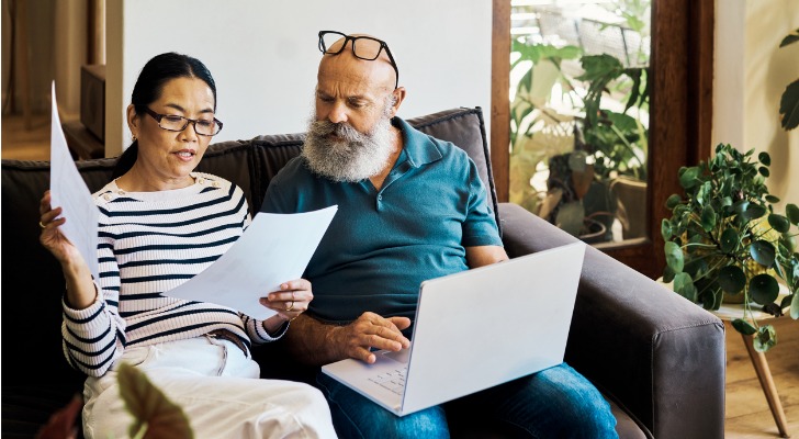 A couple looks over their paystubs as they decide how much to contribute to their Roth IRAs.