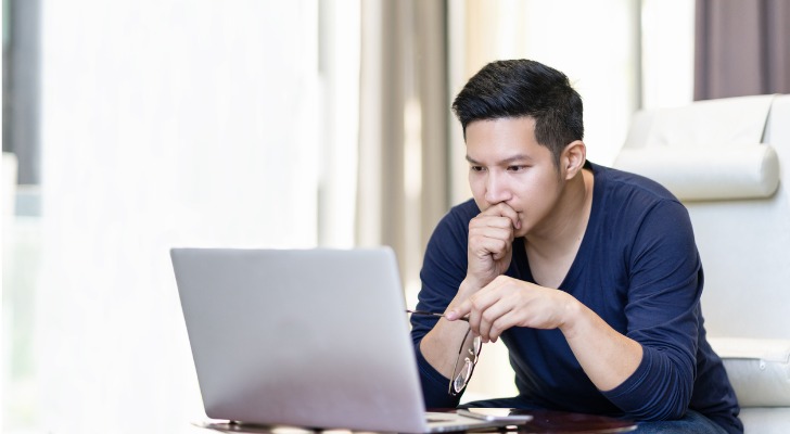 A man researches high-yield savings accounts and looks for one with an especially high APY.