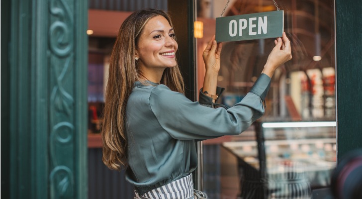 A small business owner opens her store in the morning.