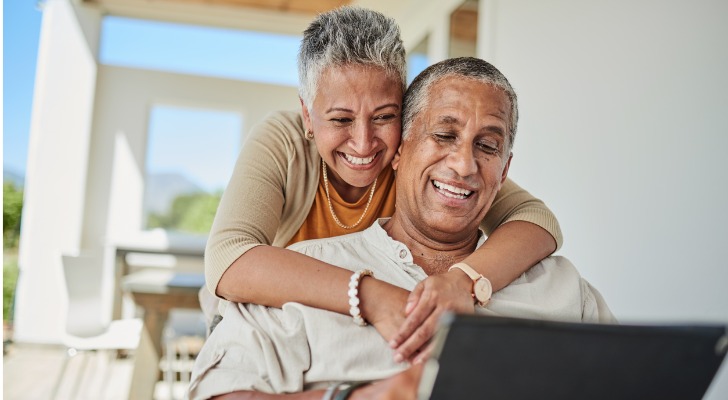 A couple sets up a spousal IRA on a laptop.
