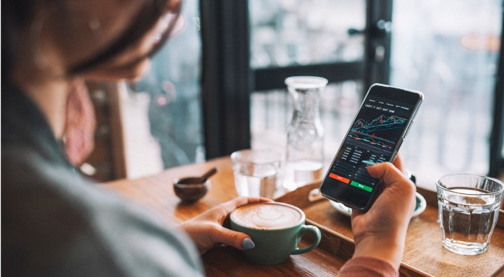 A woman checks on the performance of an ETF in her portfolio while sitting in a cafe.
