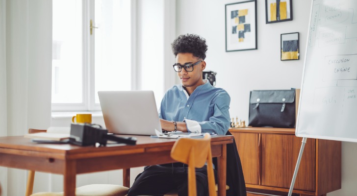 A man writing on his blog for financial advisors.