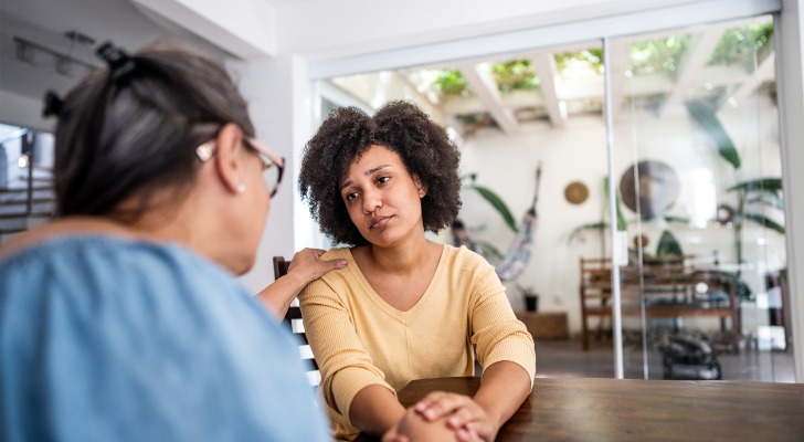 A woman is consoled after the death of her mother.