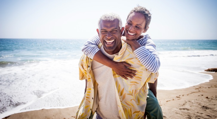 A married couple that owns property as tenants by the entirety walks together along a Florida beach.