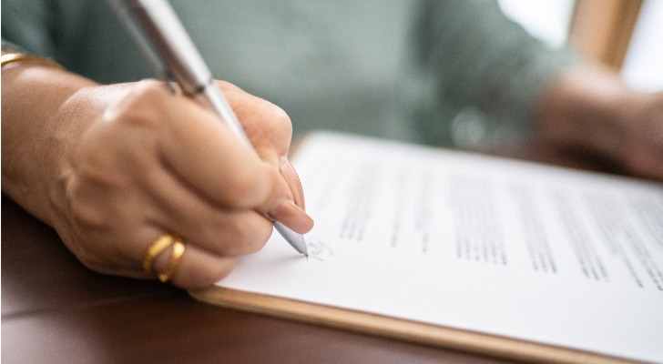 A woman signs trust documents establishing a living trust in California.