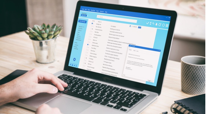 A financial advisor drafts a prospecting email on his laptop.