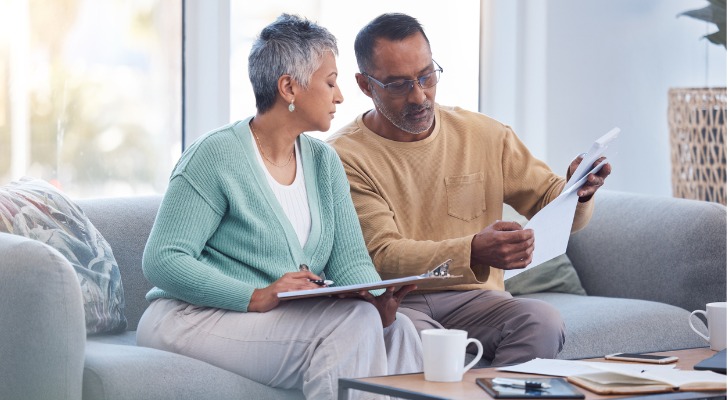 A couple reviews life insurance policies in their living room.