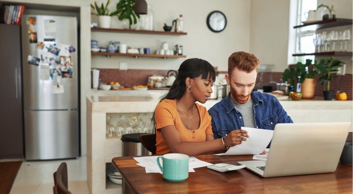 A couple files their joint tax return from their kitchen table.
