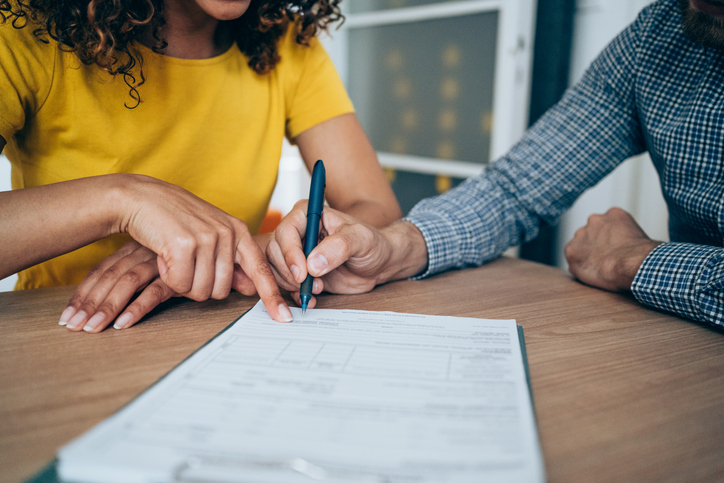 A couple fills out paperwork to apply for a business grant.