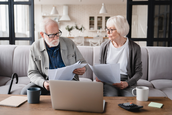 A senior couple dealing with unexpected Social Security taxes, commonly referred to as the Social Security tax torpedo.
