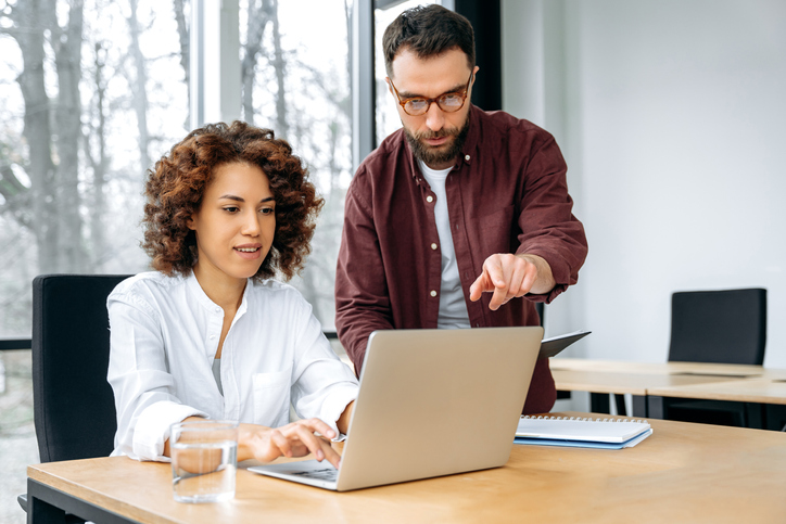 Two financial advisors developing a direct mail marketing strategy.