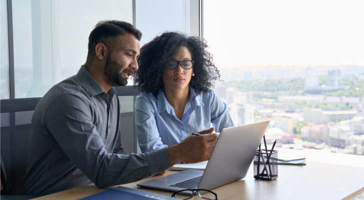 Financial advisors review a new portfolio analysis software together.