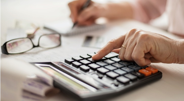 A woman adds up her monthly expenses and compares them to her retirement income.